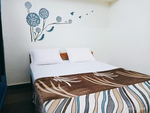 a bedroom with a bed with flowers on the wall at Freshup & Stay in Chikmagalūr