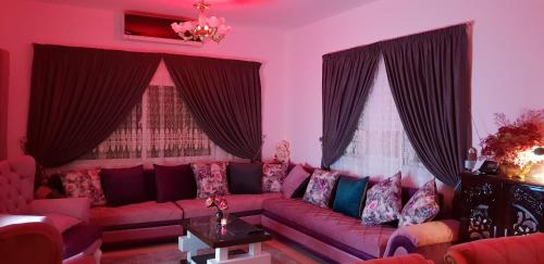 a living room with a red couch and two windows at Al Dora Residence Appartement in Hurghada