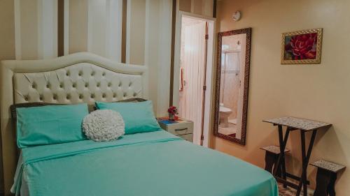 a bedroom with a blue bed and a mirror at Hostel Paraíso in Arraial do Cabo