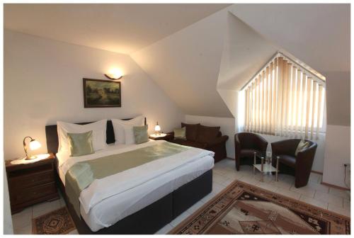 a bedroom with a king sized bed and a staircase at Restaurant penzion u Buchlovskeho zamku in Buchlovice