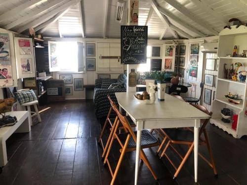 un restaurante con mesa y sillas en una habitación en Charmosa Casa pertinho do morro do céu, en Laguna