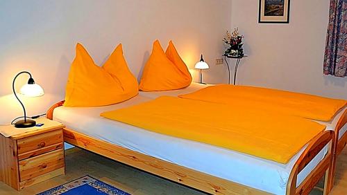a bedroom with a bed with orange pillows at Ferienwohnung Neuhuber in Bad Goisern