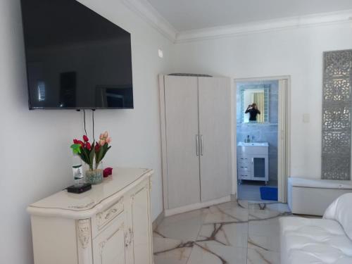 um quarto branco com um armário branco e uma cozinha em Casa 57 em Pietermaritzburg