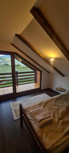 a bedroom with a bed and a large window at The Lake Breeze Bay in Plav