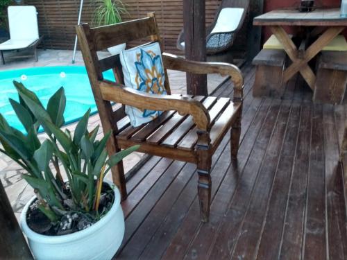 a wooden chair sitting on a deck next to a plant at Solar Lisboa 100 m da Praia com vista para mar in Balneário Camboriú