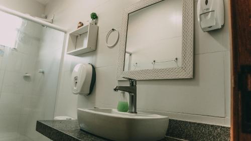 a bathroom with a sink and a mirror at Hostel Paraíso in Arraial do Cabo