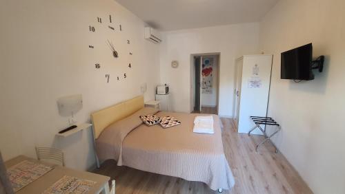 a small bedroom with a bed and a tv at Le camere di Sabrina con bagno in camera in Sarzana