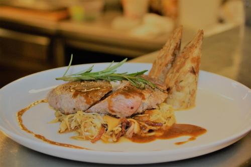a plate of food with a piece of meat and vegetables at Hotel Wechselberger by Alpeffect Hotels in Saalbach Hinterglemm