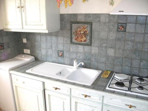 une cuisine avec un évier et une cuisinière dans l'établissement Grand appartement pour 6 pers dans une résidence de standing avec piscine à 2 pas de la plage et du centre ville, à Cavalaire-sur-Mer