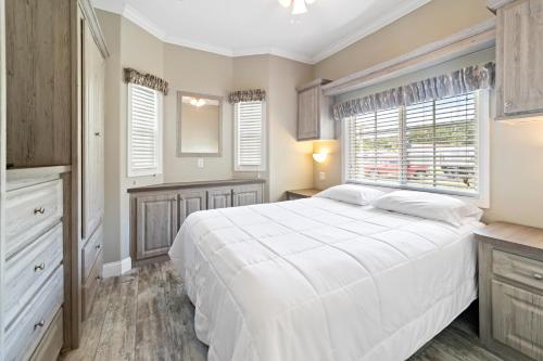 a bedroom with a white bed and a window at Sun Outdoors Sarasota in North Sarasota