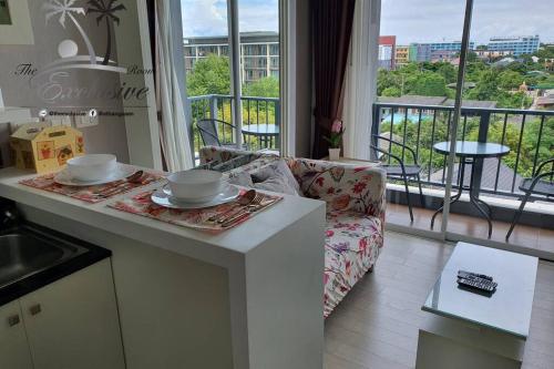 a kitchen with a table and a couch and a balcony at Love & Relax Balcony near WON Beach in Bangsaen