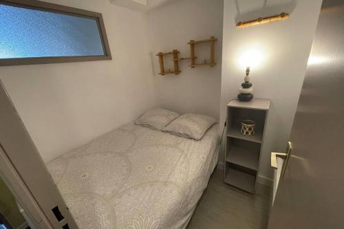 a small bedroom with a bed and a night stand at T2 pla d'adet au pied des pistes in Saint-Lary-Soulan