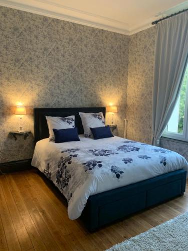 een slaapkamer met een groot bed met blauwe kussens bij L'hostellerie du chateau in Mesnil-Saint-Nicaise