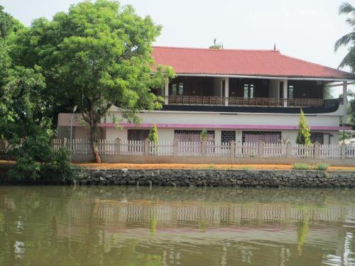 a house next to a body of water at Backwater Breeze in Kumarakom