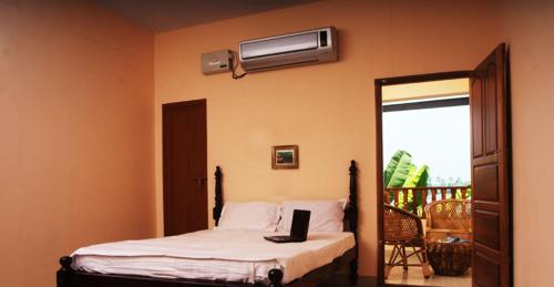 - une chambre avec un lit et un ordinateur portable dans l'établissement Backwater Breeze, à Kumarakom