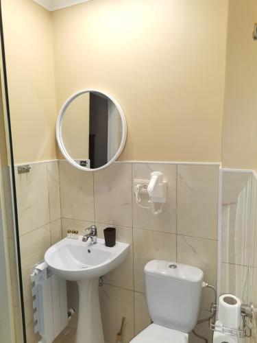 a bathroom with a toilet and a sink and a mirror at Kavaler inn hotel in Kuty