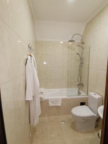 a bathroom with a tub and a toilet and a sink at Kavaler inn hotel in Kuty
