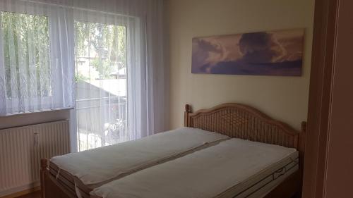 a bed in a room with a large window at 2 Zimmerwohnung am Flughafen Schönefeld in Berlin