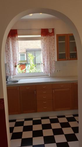 einen Torbogen in einer Küche mit einem Waschbecken und einem Fenster in der Unterkunft 2 Zimmerwohnung am Flughafen Schönefeld in Berlin