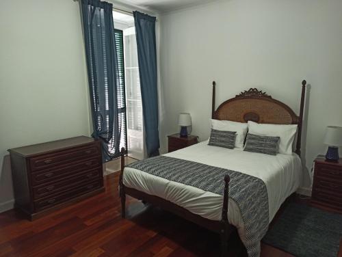 um quarto com uma cama, uma cómoda e uma janela em Alojamento Fernandes em Horta