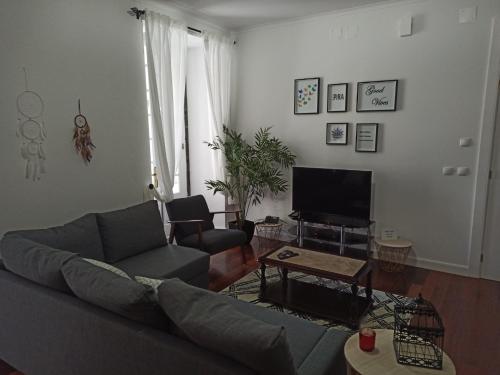 a living room with a couch and a tv at Alojamento Fernandes in Horta