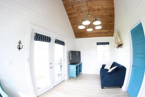 a living room with a blue chair and a tv at The Ledges Resort & Marina in Alexandria Bay