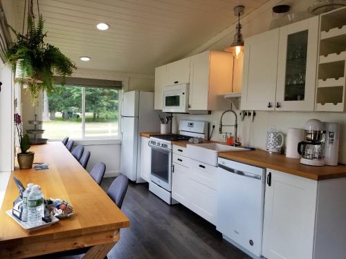a kitchen with white cabinets and a wooden table at The Ledges Resort & Marina in Alexandria Bay