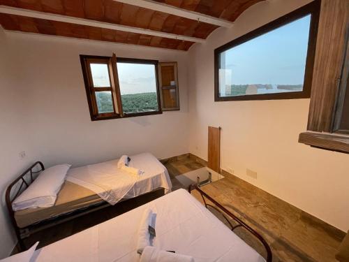 2 Betten in einem Zimmer mit 2 Fenstern in der Unterkunft La zarzuela in Algarinejo