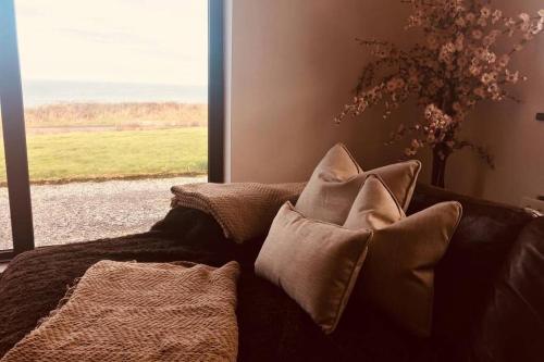 a couch with pillows in a room with a window at Apartment on Wild Atlantic Way in Fanore