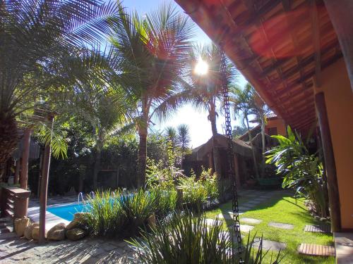 a yard with palm trees and a swimming pool at Pousada da Terra Paraty in Paraty