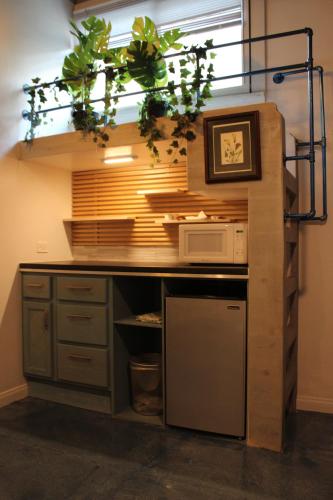 a kitchen with a counter with a microwave and some plants at Hotel Royal in Long Beach