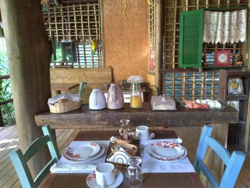 a table with plates and utensils on it at Pousada da Terra Paraty in Paraty