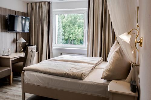 a hotel room with a bed and a window at Bach Hotel in Porta Westfalica