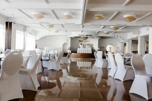 a room with white chairs and tables in a room at Bach Hotel in Porta Westfalica