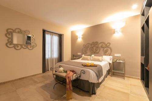 a bedroom with a large bed and a television at Palacete 1620, Premium Suites, Only adults in Granada
