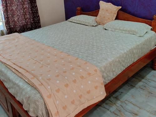 a bed with polka dot sheets and pillows at Akash homestay in Hampi