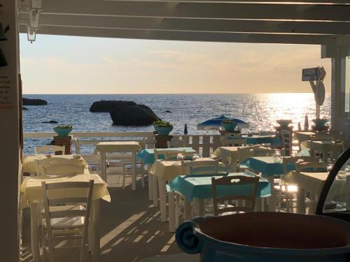 um restaurante com mesas e cadeiras na praia em Agata Suite em Ischia