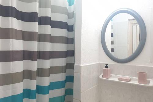 La salle de bains est pourvue d'un rideau de douche et d'un miroir. dans l'établissement chalet typique 50 m de la mer, à Gruissan