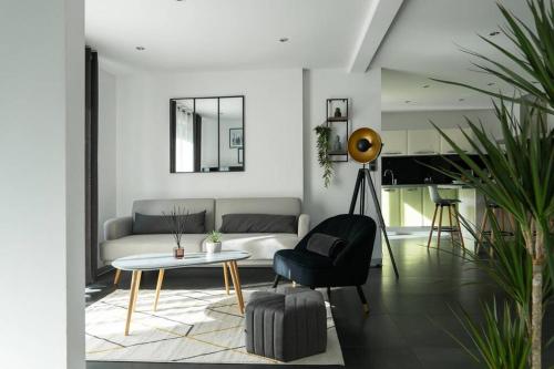 un salon avec un canapé et une table dans l'établissement La Villetta G Blotzheim - Appartement de Standing, à Blotzheim