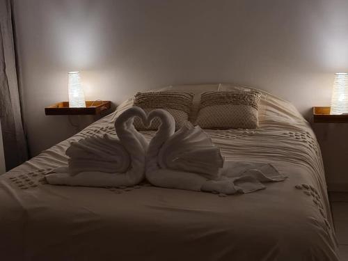 two swans making a heart on a bed at Gîte l'instant T in Thorigny
