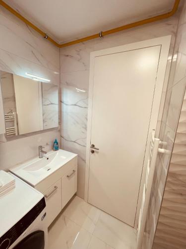 Apartment 7 في سراييفو: حمام أبيض اللون مزود بدش ومغسلة