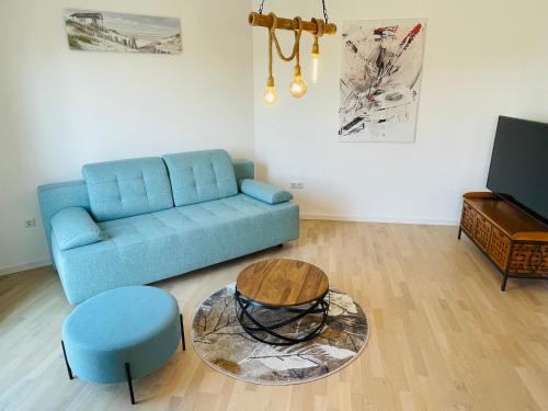 un salon avec un canapé bleu et une table dans l'établissement Apartment 7, à Sarajevo