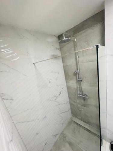 un bagno con doccia con piastrelle bianche di Apartment 7 a Sarajevo