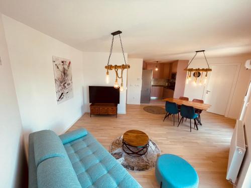 - un salon avec un canapé bleu et une table dans l'établissement Apartment 7, à Sarajevo