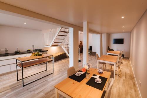 a living room with a dining table and a staircase at CITY STONE HOUSE in Ponta Delgada