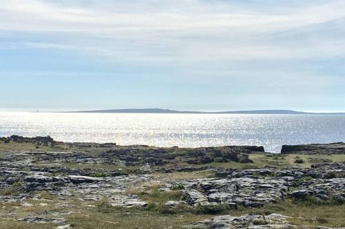 a large body of water with rocks and the ocean at Wild Atlantic Way Apartment in Fanore