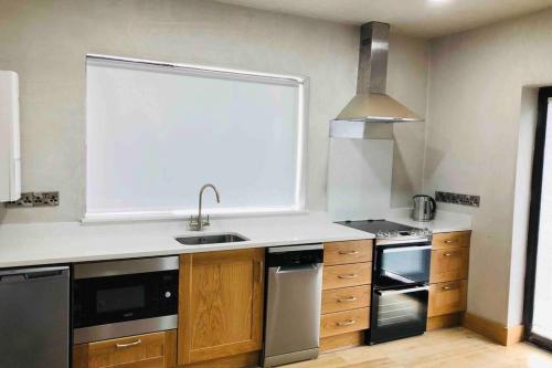 a kitchen with a sink and a large window at Wild Atlantic Way Apartment in Fanore