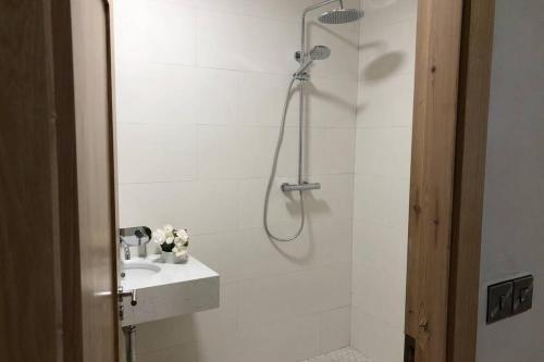 a white bathroom with a shower and a sink at Wild Atlantic Way Apartment in Fanore