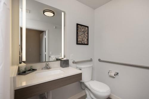 a bathroom with a toilet and a sink and a mirror at Comfort Inn Hayward - Union City in Hayward