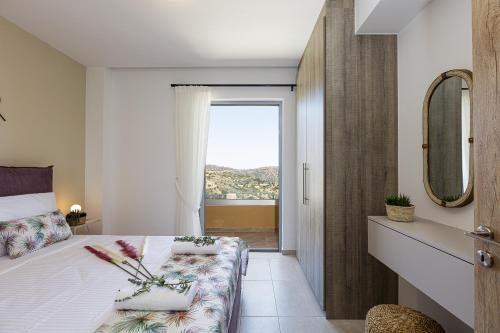 a bedroom with a bed and a window with a view at Villa Zoe , south Crete , Triopetra in Triopetra